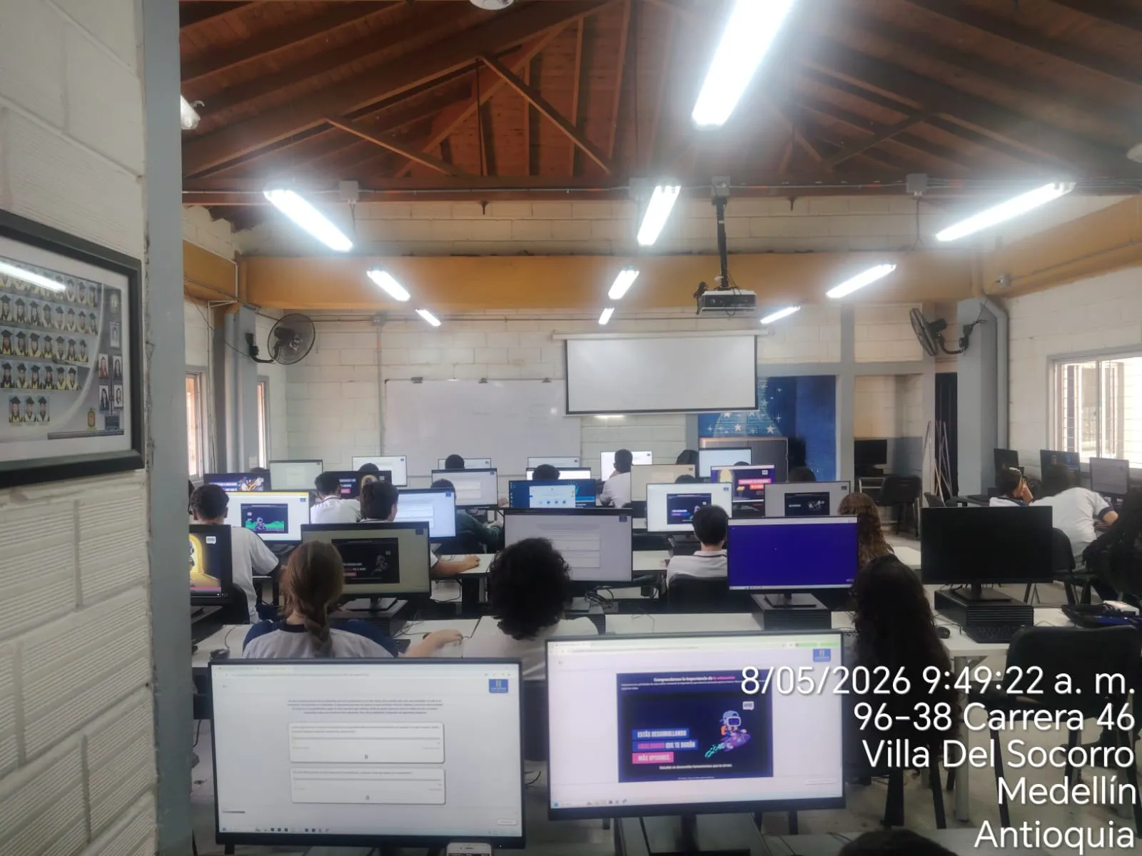 Una sala de cómputo completa usando MELO CREO, con la mascota robot de MELO en pantalla